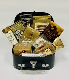 a black suitcase filled with lots of different types of chocolates and candies in it