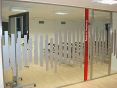 an office with mirrored walls and red tape on the glass wall, along with white partitions