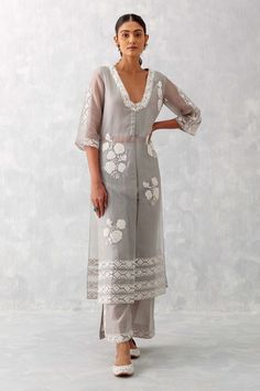 Grey kurta features contrast floral thread embroidery over the neckline and a front slit. Comes with embroidered straight palazzo with side slit detailing.
Components: 2
Pattern: Embroidered
Type Of Work: Floral Pattern
Neckline: Blunt V-Neck
Sleeve Type: Straight Three Quarter
Fabric: Silk Organza 
Color: Grey
Other Details: 
Front and side slit kurta
Side slit palazzo
Occasion: Mehendi and Haldi - Aza Fashions Organza Suits Indian, V Neck Kurti Design, Organza Kurti Designs, Straight Kurti Designs, Long Kurti Patterns, Organza Kurti, Organza Kurta, Grey Kurta, Organza Suits