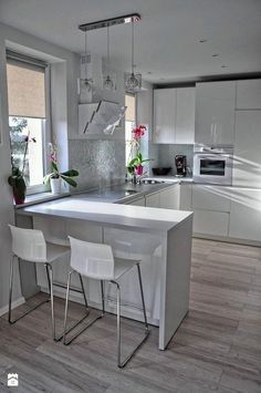 a kitchen with an island and three chairs next to the counter top in front of a window