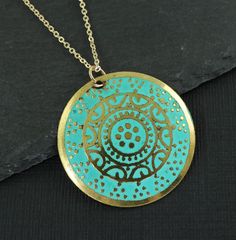 Turquoise and gold medallion necklace features a round gold disc embossed with an ornate design and colored with turquoise enamel. Pendant has a distressed feel with some dark areas on the pendant. This is part of its style. Pendant is 1 3/16 inches in diameter (30mm). Your choice of chain lengths - 16 or 18 inches. Chain is gold plated. Find more necklace styles here - https://www.etsy.com/shop/CharleneSevier?ref=hdr_shop_menu&section_id=10084290 Sign up for my newsletter! Copy and paste this link in your browser - http://eepurl.com/iSq7Wc ---------------------------------- PLEASE READ: This item is not intended for children where choking is a hazard. ---------------------------------- Green Coin Pendant Medallion Jewelry, Bohemian Gold Necklace With Patina, Blue Coin Pendant Jewelry, Gold Circle Jewelry For Festivals, Gold Circular Jewelry For Festivals, Gold Circular Festival Jewelry, Blue Medallion Necklace With Coin Pendant, Turquoise Engraved Round Pendant Necklace, Bohemian Engraved Turquoise Necklaces