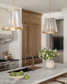 a kitchen with two lights hanging over the island