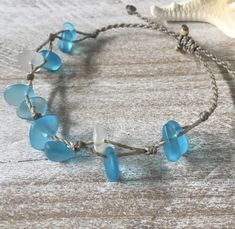 Gorgeous beach bracelet or anklet made with turquoise blue and white sea glass pebbles on our durable hand spun rope cord. Pure island style! Easy and secure adjustable slide knot closure allows for easy on and off. This bracelet/anklet is completely waterproof and metal free making it perfect for anyone with skin sensitivities and is a wonderful and unique gift for those hard to shop for friends and family on your list, especially the beach lovers! Color: Turquoise blue Size: Available in three Cheap Blue Bracelets For Beach, Beach Glass Bracelets, Cheap Blue Beach Bracelets, Adjustable Recycled Glass Bracelets As Gift, Handmade Adjustable Sea Glass Bracelets, Turquoise Hand-strung Braided Bracelet For Beach, Adjustable Ocean-inspired Sea Glass Jewelry, Adjustable Strand Jewelry With Sliding Knot, Adjustable Ocean-inspired Friendship Bracelet