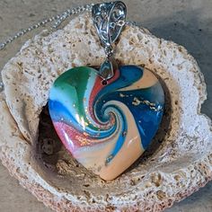 Beautiful Swirl Necklace In Shades Of Blues, Greens, Pinks And Peaches. Accompanied By A 18" Silver Chain, This One-Of-A-Kind Necklace Will Make A Fantastic Statement Piece To Any Outfit! Pendant Measures Approximately 1.25"H X 1.25"W. From A Non-Smoking Home. Cc7 Multicolor Spiral Necklace Gift, Spiral Multicolor Necklace Gift, Unique Blue Heart-shaped Necklace, Unique Blue Jewelry For Valentine's Day, Unique Blue Jewelry With Heart Charm, Unique Blue Heart Pendant Necklace, Blue Spiral Necklace For Gift, Swirl Necklace, Peaches