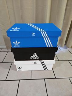 three adidas boxes stacked on top of each other