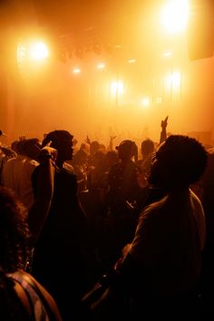 a group of people standing in front of a crowd at a music concert with bright lights