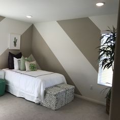 a bedroom with white bedding and green accents on the walls, carpeted flooring