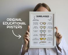 a woman holding up a framed poster with glasses on it's front and side