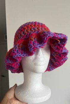 a white mannequin head wearing a pink and purple crochet sun hat