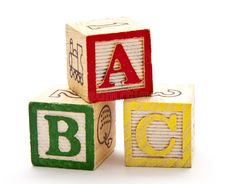 three wooden blocks with letters that spell out abc and letter c in different colors, on a white background