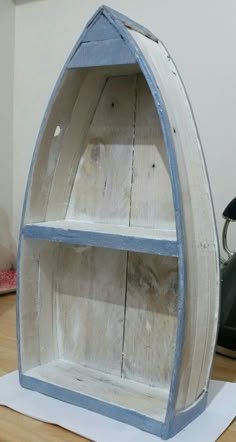 a boat shaped shelf sitting on top of a wooden table