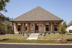 a small brick house sitting on the side of a road