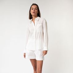 The Linen Voile Signature Shirt is made from premium Linen Voile, featuring a relaxed straight cut with a concealed button placket for a refined and polished appearance. It can be styled with or without a belt and includes a neat collar, yoke, and breast pocket, ensuring both functionality and style.  The crisp white colour provides a clean, bright look for a fresh, modern outfit.  Its semi-transparent nature offers a light and breezy feel, ideal for relaxing at home, casual daytime wear, or bea Elegant Lounge, Poplin Shorts, Shirt Blouses Women's, Loungewear Dresses, Dressing Gown Robe, Relaxed Outfit, Nightwear Women, Silk Camisole, Silk Shorts