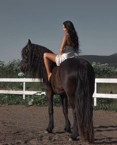 a woman sitting on the back of a brown horse