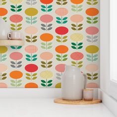 a kitchen wall with colorful flowers and leaves on it