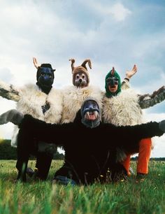 three people with masks on their faces are sitting in the middle of a grassy field