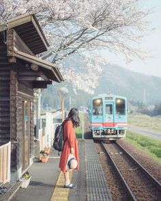 a woman is waiting for the train to arrive