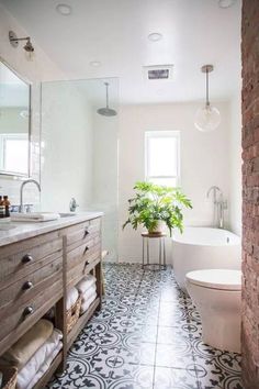 a bathroom with black and white tile flooring next to a bathtub, toilet and sink