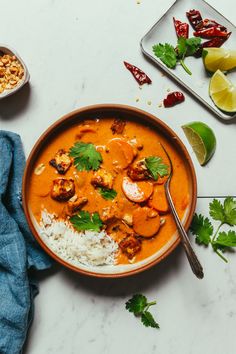 a bowl of food with rice, meat and vegetables on the table next to it