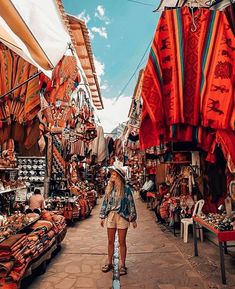 a woman is walking through an outdoor market