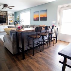 a living room filled with furniture and a flat screen tv mounted to the side of a wall