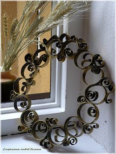 an image of a wreath on the window sill that is decorated with metal swirls