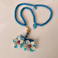 a blue beaded necklace with flowers on it