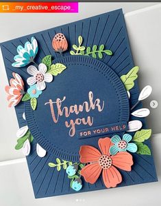 a thank you card with flowers and leaves on the front, in navy blue paper