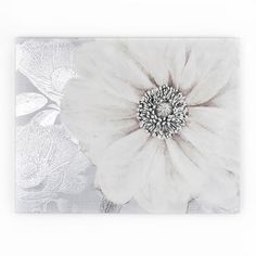 a white flower on a gray background with black and white flowers in the bottom right corner