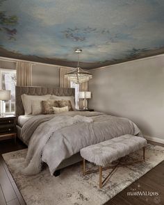 a large bed sitting in a bedroom next to a lamp on a wooden floor and a painting on the ceiling