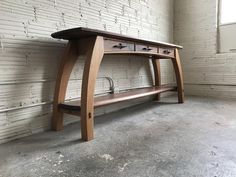 a wooden desk sitting in front of a white brick wall