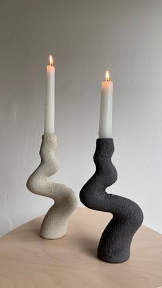 two candles sitting on top of a wooden table