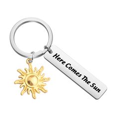 a keychain that says, here comes the sun with an image of a sun on it