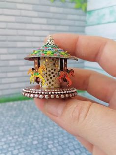 someone is holding a miniature carousel in their hand