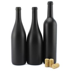 three black bottles with corks next to them