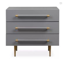 a grey and gold dresser with two drawers on it's sides, one drawer has three brass handles