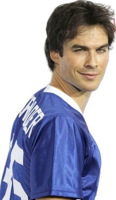 a young man in a football uniform is posing for a photo with his hair pulled back