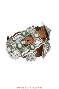 TIMELESS AND TRADITIONAL This stunning belt has an alternating design of scalloped conchos each featuring a single turquoise cabochon, and simple butterfly spacers. The rectangular double mustache buckle has four matching turquoise cabochons. The silverwork features traditional scalloped edges with hand stamped designs and repousse styling throughout. The conchos are seated on a supple brown leather belt. This is a timeless classic and a collector’s piece. affiliation: Navajo materials: sterling Luxury Adjustable Jewelry With Antique Buckle, Vintage Turquoise Belt With Concho, Turquoise Bohemian Belt With Concho, Adjustable Turquoise Vintage Belt, Vintage Adjustable Turquoise Belt, Adjustable Vintage Turquoise Belt, Turquoise Western Belt With Concho, Western Turquoise Belt With Concho, Turquoise Bohemian Belt Buckle With Antique Detail