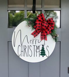 a merry christmas sign hanging on the front door