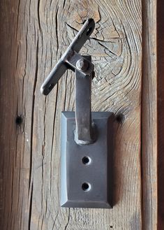 an old door handle on the side of a wooden door with nails stuck in it