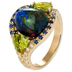 Black opal, sapphires, peridots, diamonds 14k gold ring. Genuine opal ring. Opal 14k gold cocktail ring. Multicolor gold ring. Metal: 14 karat gold. Weight: 3 gr (depends from size). Gemstones Main gemstone: Opal, oval cabochon, color: black - multicolor, weight 1.5 ct aprox., semi - transparent. Play of color of opals depends from light. All photos are done under pen light. Peridots, trillione cut, 1.2 ct, apple green color, transparent. Sapphires: round cut, blue color, transparent with inclus Apple Green Color, Round Diamond Setting, Baguette Diamond Rings, Purple Diamond, Ring Opal, Padparadscha Sapphire, Gold Cocktail Ring, Gold Cocktail, Diamond Cocktail Rings