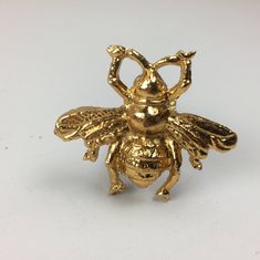 a gold colored metal figurine of a bee