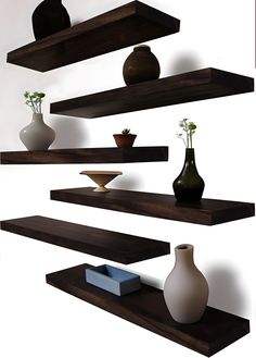 three wooden shelves with vases on them