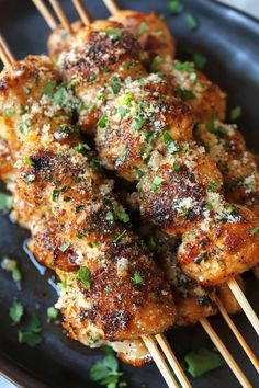 chicken skewers with parmesan cheese and herbs on them are ready to be eaten