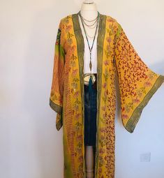 "A Stunning Embroidered and Sequinned Boho Kimono Jacket. Long,loose and floaty in Silk ;Perfect to layer for Holidays , Festivals and Parties. This is Handmade from a Vintage Indian Sari. so completely Unique and Sustainable. A Wonderfully Chic and Flattering Lime and Yellow Printed Silk Jacket, Beautifully embroidered allover with an exquisite floral design in contrasting bright summer colours , and with Silver Sequins, Beads and Coloured stones. It is really light, cool and floaty , with Stylish Kimono sleeves and a sash belt to adjust the fit .  This Lovely piece is truly unique ,and will look stunning dressed up or down for years to come ; layered casually at festivals or lunches , or for evening dinners, parties and Celebrations .  Will fit and flatter sizes  S M L .     UK 8  to 14 Mustard Kimono Outfit, Yellow Bohemian Kimono With Kimono Sleeves, Festival Printed Yellow Kimono, Orange Long Sleeve Kimono For Festivals, Festival Yellow Printed Kimono, Bohemian Yellow Long Sleeve Kimono, Yellow Printed Kimono For Festival, Summer Festive Embroidered Kimono, Bohemian Printed Outerwear