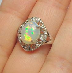 This 9mm x 11mm Ethiopian Welo, Opal has Awesome color play, displaying a Blue, Green, Red and Yellow Fire, when sun light hits the stone at different angles. This stone is loaded with fire, unfortunately I could not capture it all with the camera. I have set this beauty in a new 10k White Gold, Victorian design ring, with four Pink Zircon accents, in a size 7, resizable by your local jeweler, if need be. It is hallmarked 10k inside the band. And will come in a lovely box, for gifting. This woul Color Play, Victorian Design, Ring Color, Opal Ring, Welo Opal, Opal Rings, Pink Orange, Green Yellow, Ring Designs