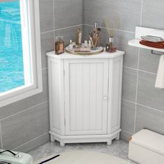 a small white cabinet in a bathroom next to a window