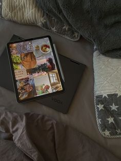 an open laptop computer sitting on top of a bed next to a pillow and blanket