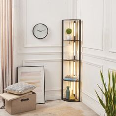 a living room with a clock on the wall next to a shelf filled with books