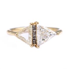 an engagement ring with three princess cut diamonds on the sides and two smaller princess cut diamonds at the top